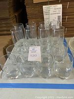 Overview of all 16 glasses on table, showing arrangement of 8 tumblers and 8 juice glasses.