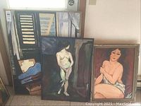 Four original paintings stacked against a wall. Three figurative nudes and one abstract.