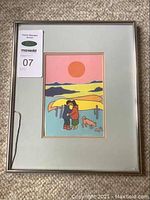 Framed Ted Harrison print with visible damage to the glass and a visible auction tag.