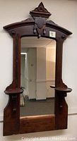 Full view of antique dresser mirror showing entire wooden frame and mirror surface.
