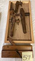 Photo showing three wooden beer keg handles in a wooden tray with aged wear and patina.