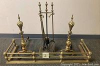 Full set of brass fireplace accessories including andirons and toolset on stand