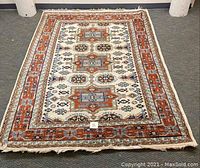 Full view of the Couristan hand woven oriental rug showing overall design and color scheme with orange border and central geometric medallions.