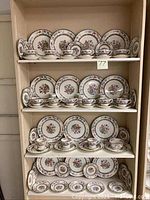 Full shelving display of dinnerware on four shelves.