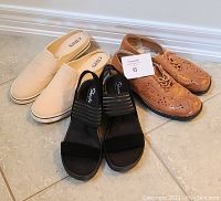 Three pairs of ladies shoes including beige Chaps slip-ons, tan leather lace-up brogues, and black Skechers sandals