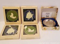 Four Hallmark Cameo Keepsake ornaments in their original boxes along with a set of silver plated coasters in floral box