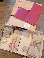 Boxes and lids arranged inside larger cardboard boxes, showing burgundy color and floral printed hexagonal boxes with ribbons.