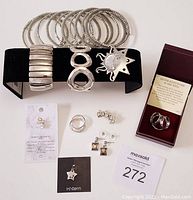 Full lot of costume jewellery and sterling silver pieces displayed on white surface.