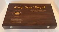 Closed wooden box with King Star Royal branding and details about the flatware set.