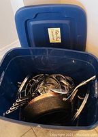 Blue plastic bin open showing cookware inside