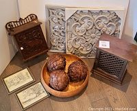 Lot showing two grey resin decorative panels, three large wooden acorns in a birdseye maple bowl, a vintage carved wooden key box, a carved jewellery box, and two framed vintage sketches.