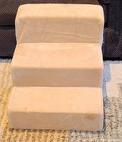 Front view of three step beige pet stairs.