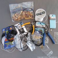 Overview of assorted beading supplies, tools, wooden beads, cords, jump rings, and findings.