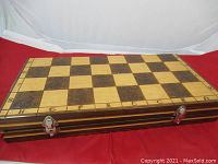 Board closed, showing carved swirl squares and metal latch closures