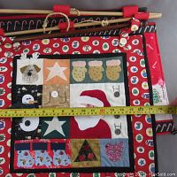 Both Christmas-themed embroidered wall hangings side by side with measuring tape showing about 18 inches width.