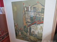 Full view of the framed print showing street and buildings with red chimney tips and leafless vines.