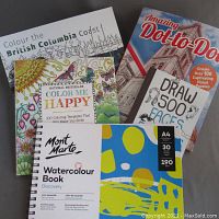 Four books arranged on a flat surface: two coloring books, one dot-to-dot puzzle book, and one watercolor paper book