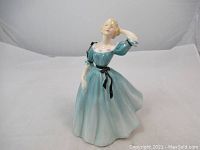 Front and side view showing full figurine detailing with turquoise dress and pose.