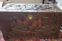 Front view of entire chest showing relief carvings and round brass lock plate