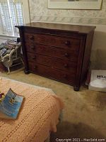 Full view of large dark wood 4-drawer dresser next to bed showing overall size and condition.