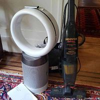 Dyson Pure Cool fan beside Hoover and Black & Decker vacuums on patterned rug