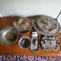 Overview of assorted silver-plated serving pieces on wooden table