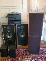 Full view of stereo system components stacked including NAD, Yamaha equipment, and multiple speakers including EPI floor-standing and PSB bookshelf speakers.