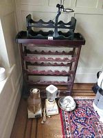 Large wooden wine rack and two small wine racks with Osterizer blender, Cuisinart food processor and attachments on floor in front.