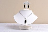 Full display of necklace and earrings on stand showing black onyx side