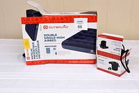 Photo showing the boxed Outbound double single-high air mattress and boxed Outbound electric air pump with nozzles.