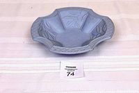 Photo of top and side view showing blue ceramic botanical bowl with leaf patterns and scalloped edges