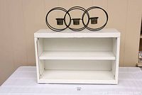 Front view of white laminated adjustable shelf with two inner shelves, visible minor laminate paper lifting on the top surface.