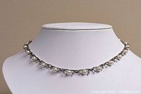 Front view of necklace on display bust showing manufactured pearls with silver tone ruthenium setting.