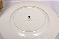 Back of a white Wedgwood plate with black stamp showing Wedgwood logo and the text 'Made Specially for the Canadian Government'. Shows condition of porcelain base.