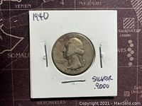 Front of 1940 Washington quarter silver coin in protective holder, showing George Washington profile and date 1940, marked 90% silver.