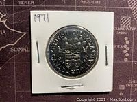 Reverse side of 1971 Canadian silver dollar coin showing British Columbia coat of arms and floral design with year 1971.