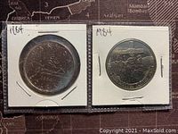 Both sides of two 1984 Canadian one dollar coins commemorating Jacques Cartier's 450th anniversary arranged and encased in holders.