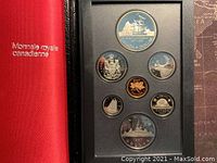 Front view of the coin set showing a large silver double dollar proof coin featuring a sailing ship, along with six other Canadian coins in proof condition displayed in a black case.