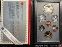 Opened display folder showing 1989 Canadian Alexander MacKenzie proof coin set including a large silver dollar and other denominations in a black tray.
