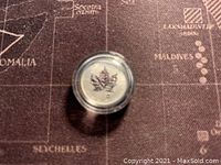 Top view of the coin showing the maple leaf design and denomination