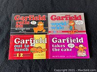 Four Garfield comic books laid out showing full front covers and titles.