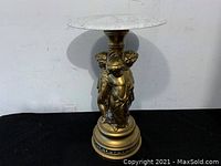 Full view of the marble top end table showing the decorative gold base with cherub figures and round marble top.