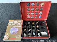 Photo depicting the full set including the rock and minerals display box and the accompanying handbook titled 'Rocks and Minerals Handbook'.