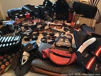 Full overview of assorted sunglasses, handbags, sandals, and perfume bottles arranged on a table