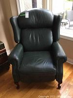 Front view showing overall shape, leather upholstery and wingback design.