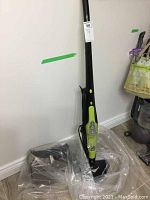 Full view of the assembled H2O HD Dual Blast steam mop standing upright, showing its black and lime green design with a triangular mop base on tiled floor.