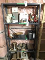 Full view of the metal shelving unit containing assorted home decor items including snowman figurines and picture frames.