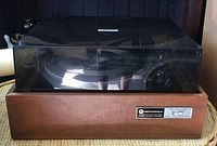 Front view of vintage Motorola turntable showing dust cover and wooden base.