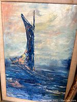 Full view of framed oil painting showing a blue sailboat with full sail on water under a cloudy sky.