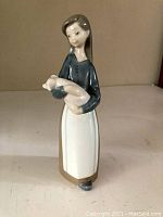 Front view of the vintage Lladro figurine showing girl holding piglet